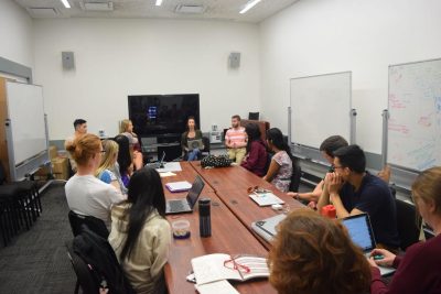 Students in the Pathways minor, Innovation, sit around a conference table to plan a prototype as part of a group project. 